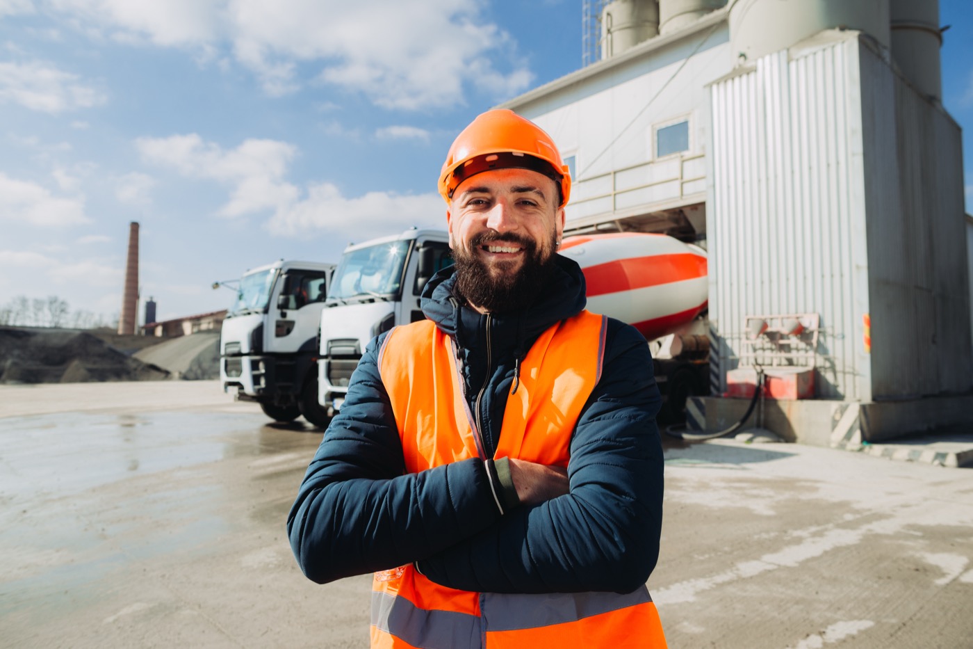 Operador de planta de materiales frente a los camiones de despacho